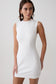 Woman wearing a white sleeveless stretch crepe mini dress.