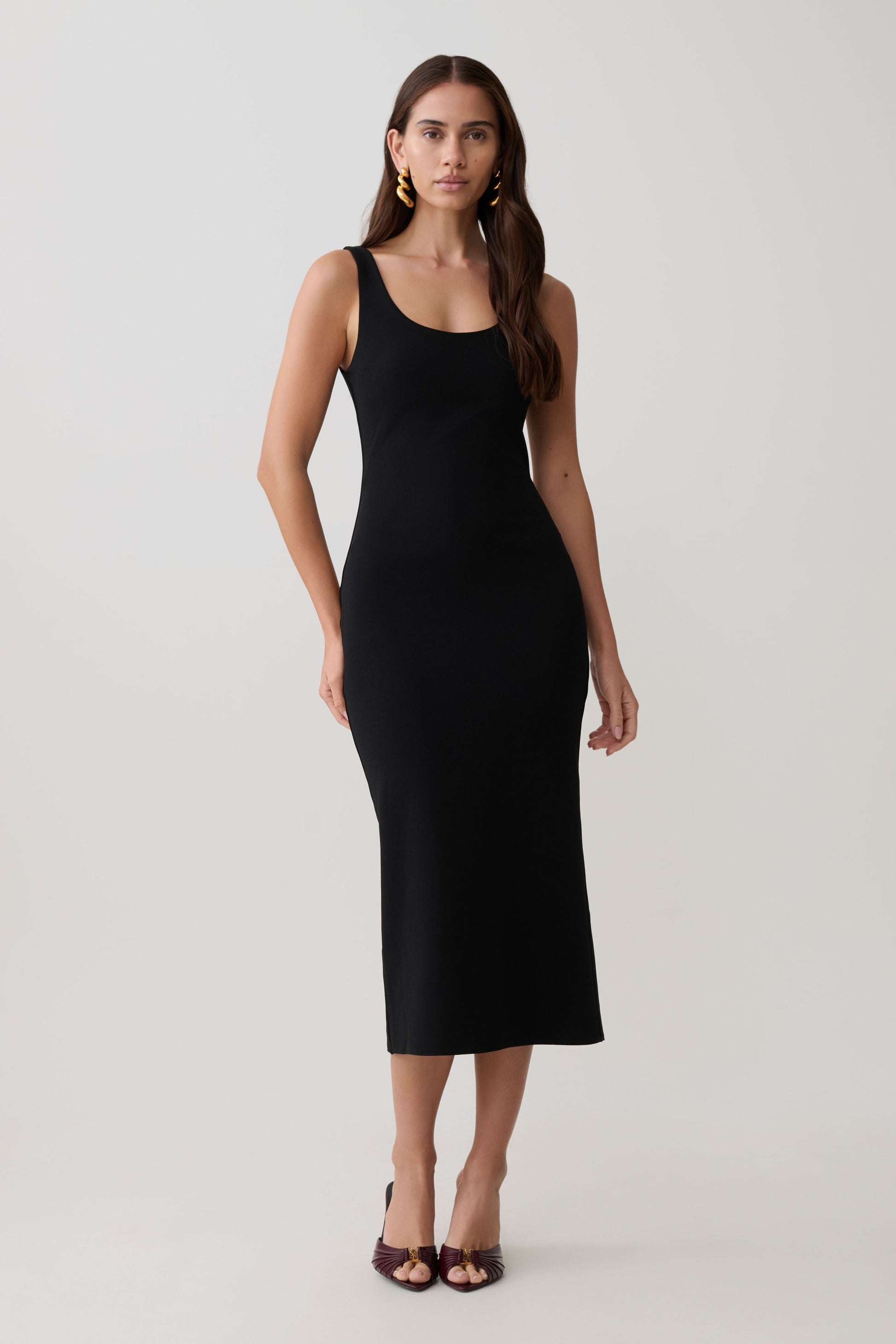 Woman wearing a black stretch crepe mini dress.