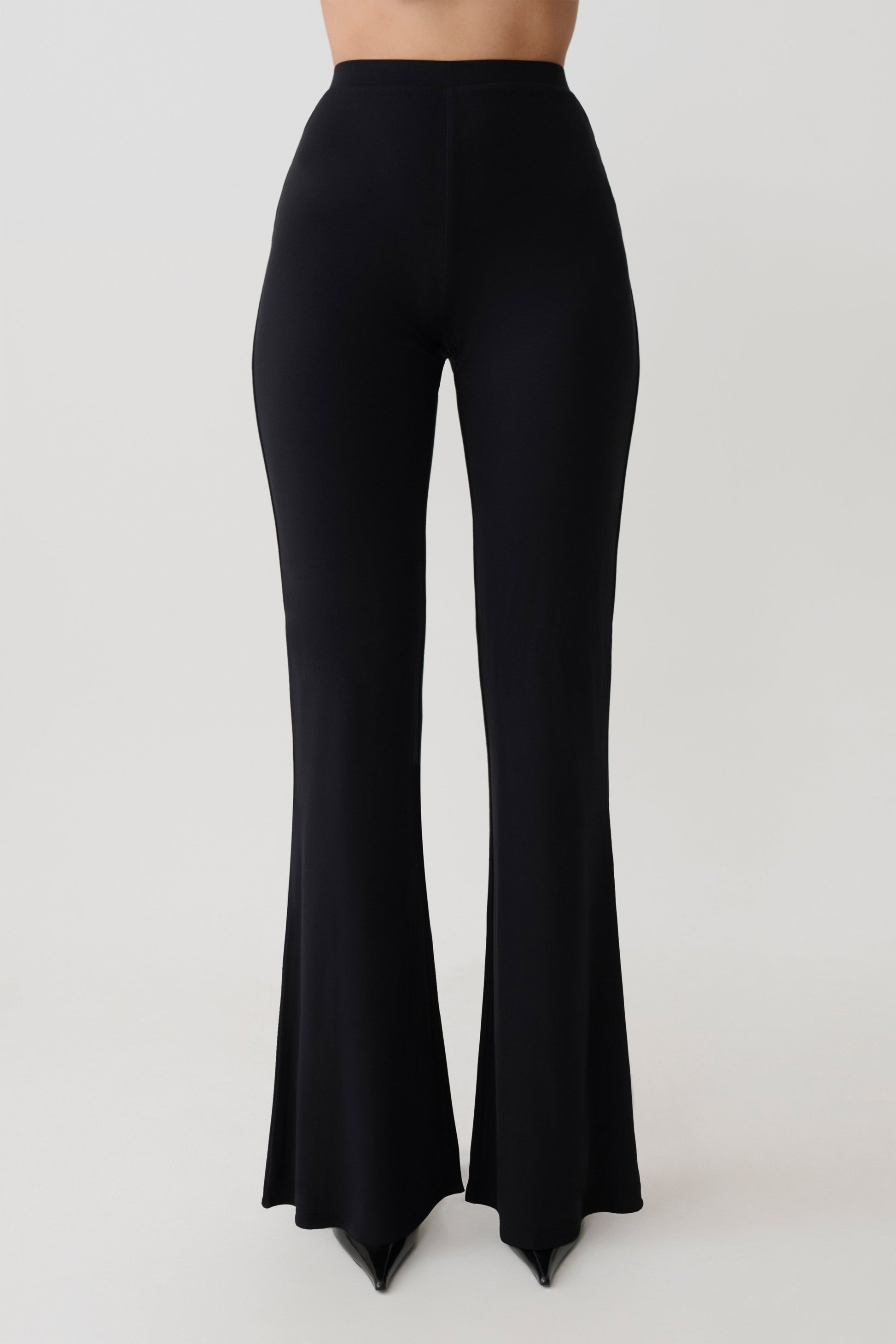 Woman wearing black flared pants.