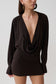 Woman wearing a brown cowl drape shirt dress.