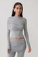 Woman wearing a grey long-sleeve overlay top.