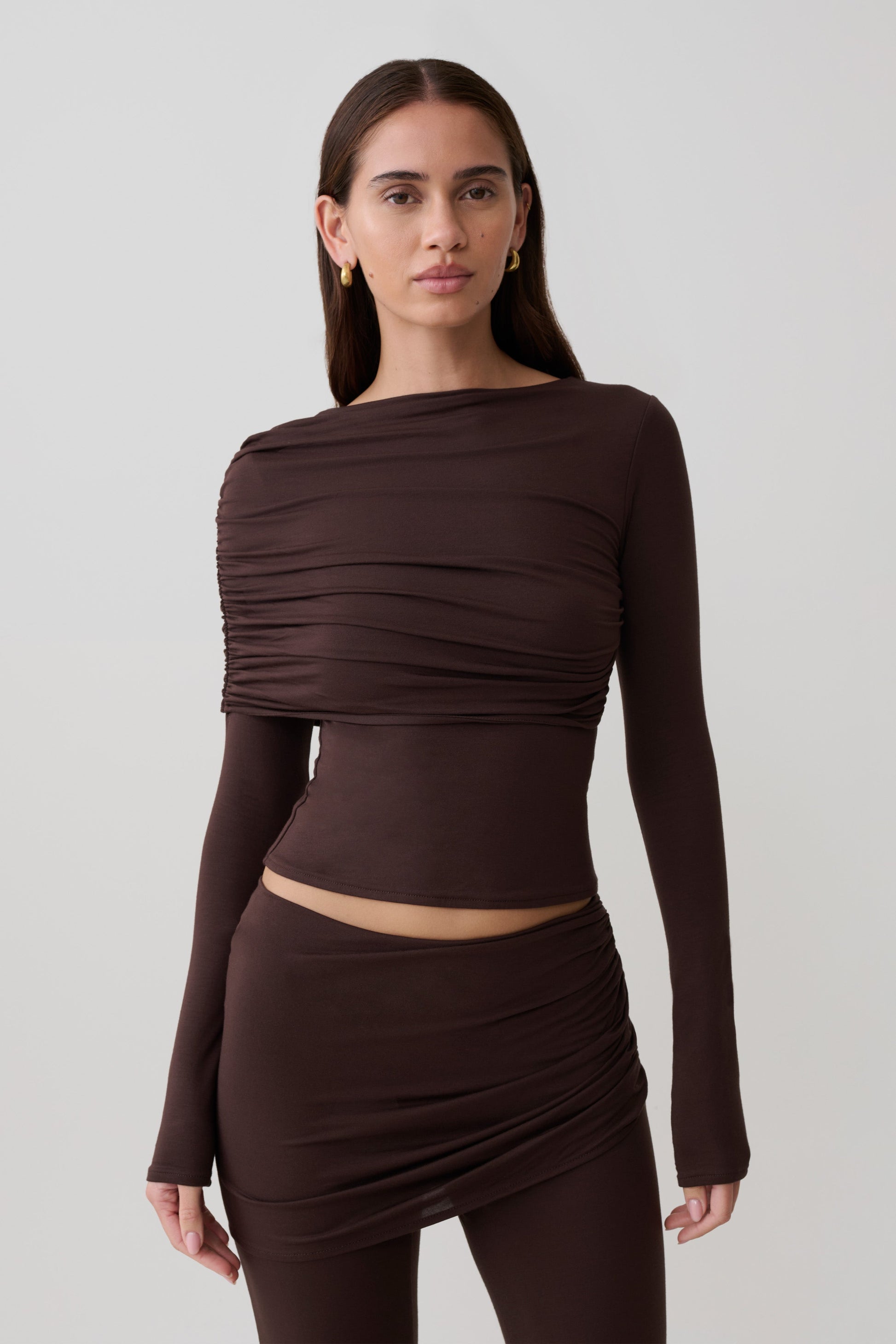 Woman wearing a brown long-sleeve overlay top.