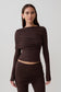 Woman wearing a brown long-sleeve overlay top.