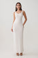 Woman wearing a white scoop neck jersey maxi dress.