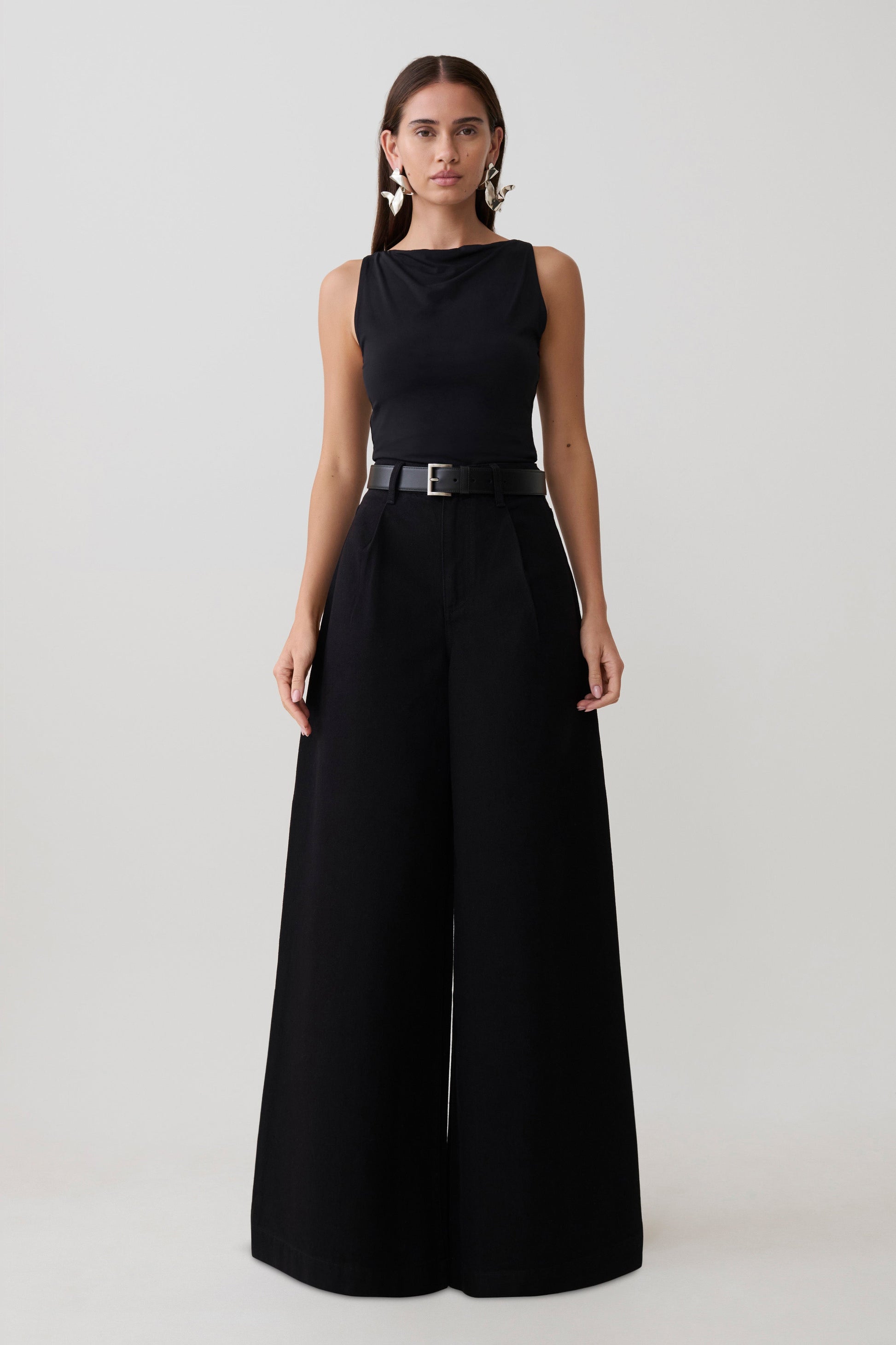 Woman wearing a black oversized jean with front pleat.
