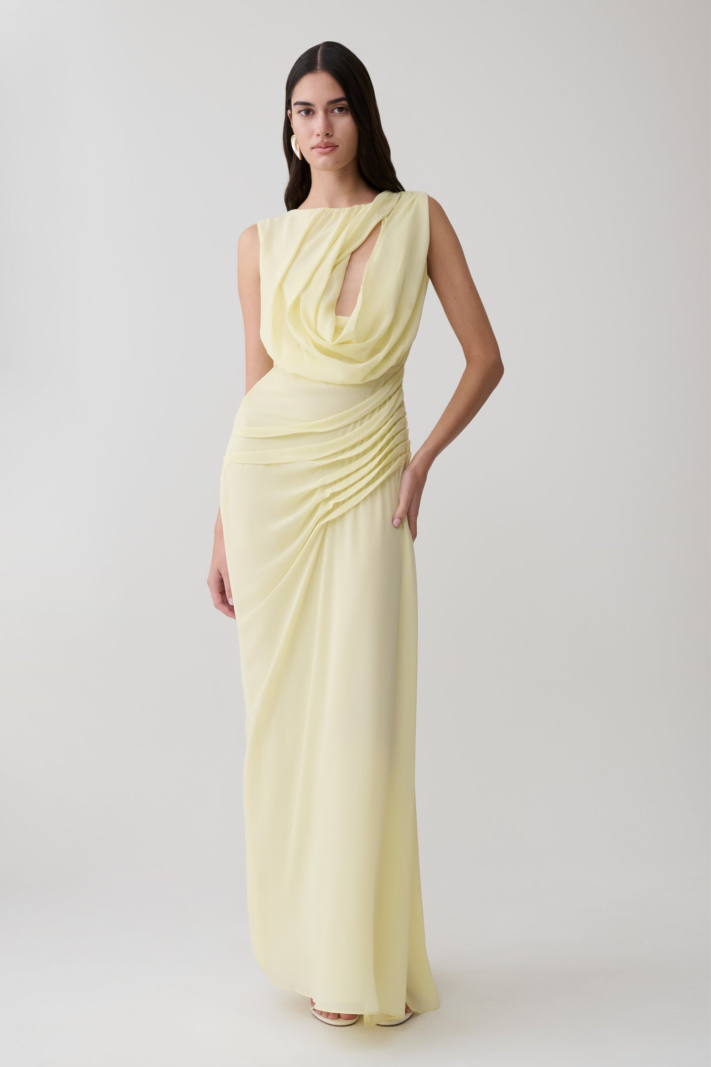 Woman wearing a light yellow chiffon maxi dress.