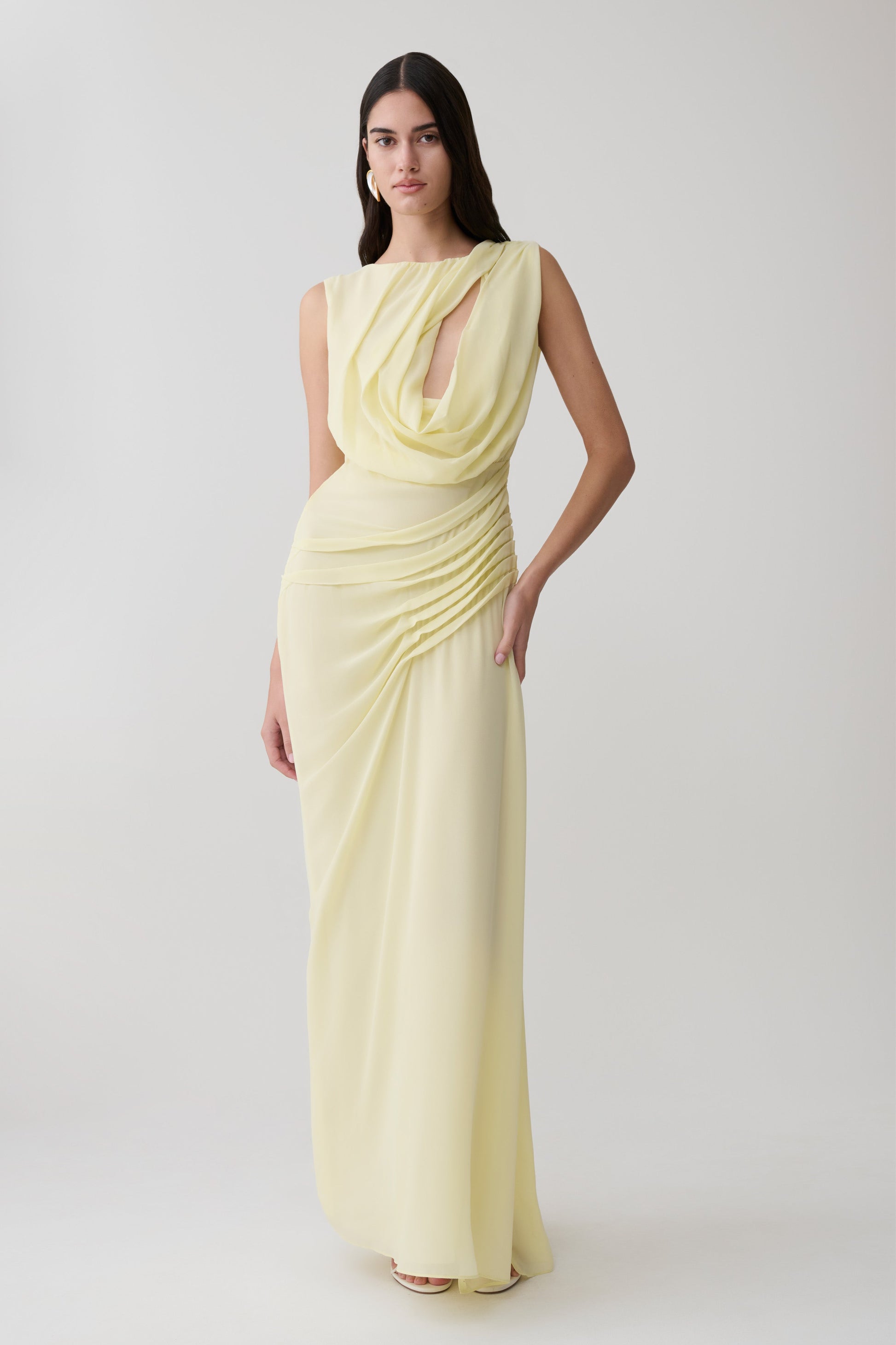 Woman wearing a light yellow chiffon maxi dress.