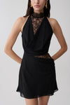 Woman wearing a black chiffon And lace halter mini dress.