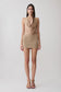 Woman wearing a gold lurex cowl neck top with matching mini skirt.