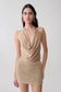 Woman wearing a gold lurex cowl neck top.