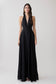 Woman wearing a black halter buttoned maxi dress.