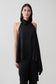 Woman wearing a black asymmetrical satin halter top.