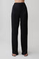 Woman wearing black straight leg satin pants.