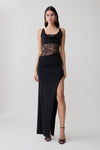 Woman wearing a black draped slinky and lace maxi dress.