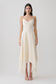 Woman wearing a white satin asymmetric hem maxi dress.