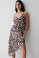 Woman wearing a zebra print low back chiffon top.