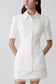 Woman wearing white button up short sleeved top.