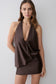 Woman wearing a brown halter neck mini dress.