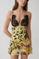 Woman wearing a yellow leopard print  lace and chiffon mini dress.