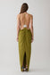 Woman wearing a green low back halter maxi dress. 