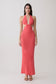 Woman wearing a coral halter knit maxi dress.