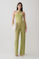 Woman wearing a green twist front knit top with matching crochet pants.