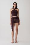 Woman wearing a brown twist front knit top with matching crochet shorts.