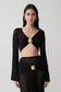 Woman wearing a black crochet long sleeve cropped top.