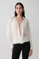 Woman wearing a white blouse with a plunging neckline.