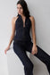 Woman wearing a dark blue halter longline denim top.