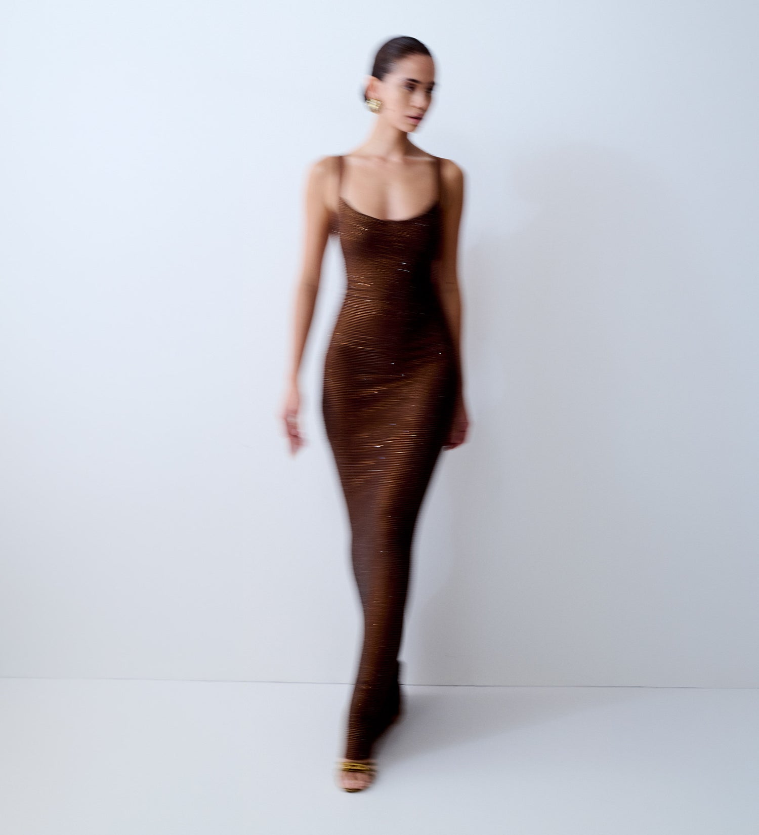 Image of woman in brown diamante maxi dress in motion