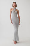 A woman modeling a light gray ribbed knit halter-neck maxi dress with a keyhole cutout at the chest, photographed against a seamless light gray studio background.