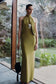 Woman wearing a green halter neck slinky maxi dress.