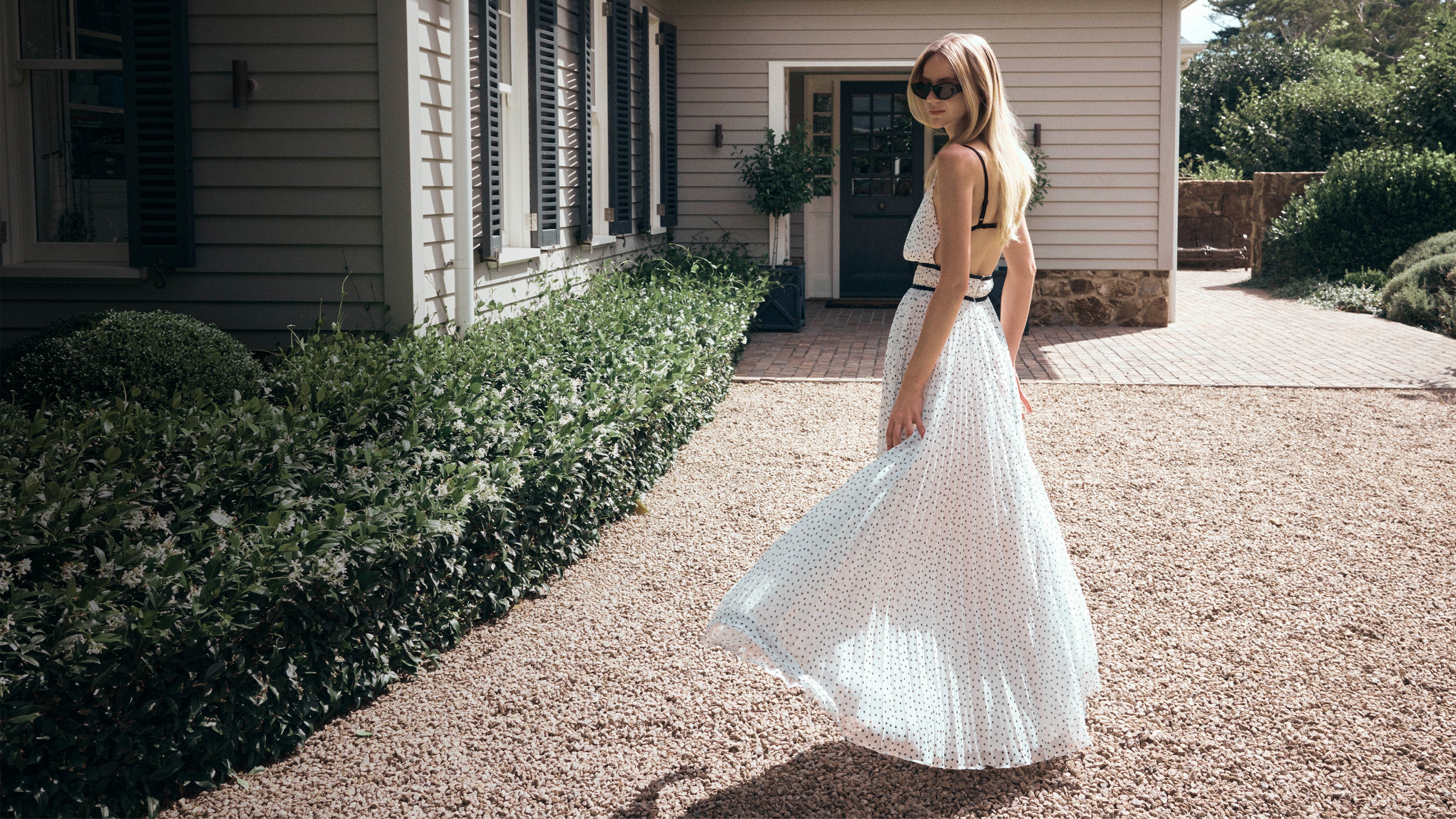 Image of woman in white polka dot maxi dress.