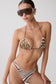 A model wearing a two-piece bikini with a brown and beige animal print on the top and a brown and white zebra stripe pattern on the bottom, styled with oversized dark sunglasses against a light gray background.