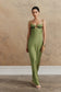 Woman wearing a green embellished satin maxi dress.