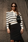 Woman wearing a black and white striped jumper with a collar.