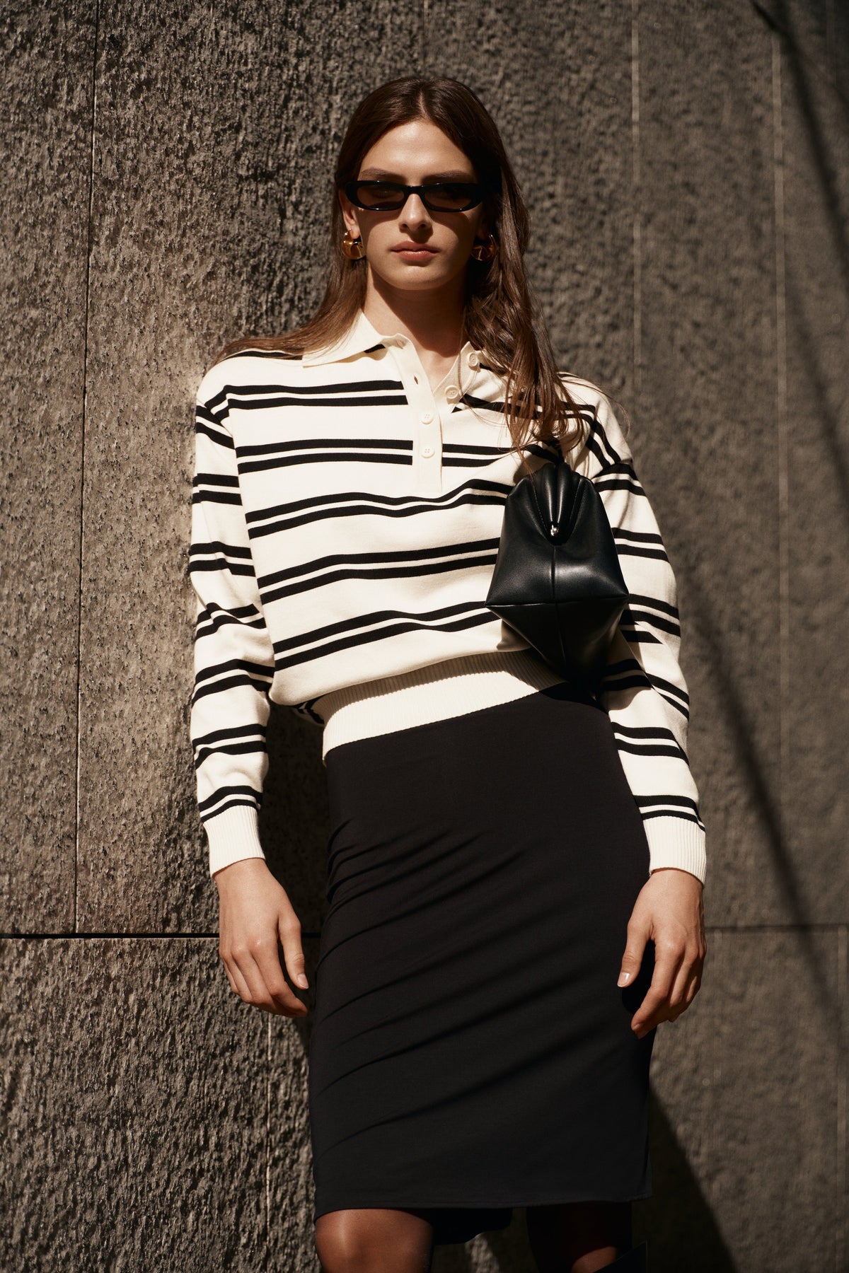 Woman wearing a black and white striped jumper with a collar.